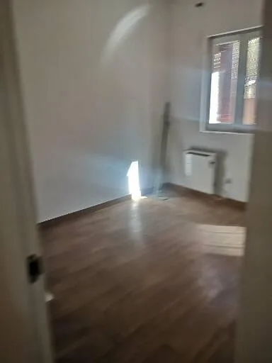 Habitación reformada con paredes blancas y suelo de madera